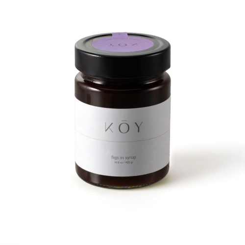 A jar of Koy figs in syrup, dark amber under a black lid with a purple seal