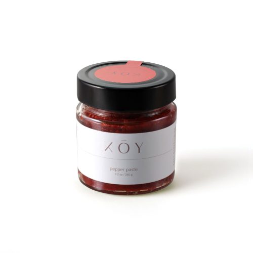 A jar of Koy pepper paste, bright red under a black lid with a red seal