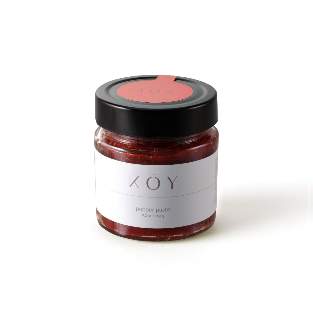 A jar of Koy pepper paste, bright red under a black lid with a red seal
