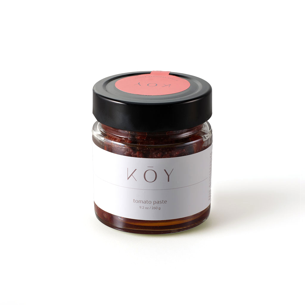A jar of Koy tomato paste, deep red under a black lid with a red seal